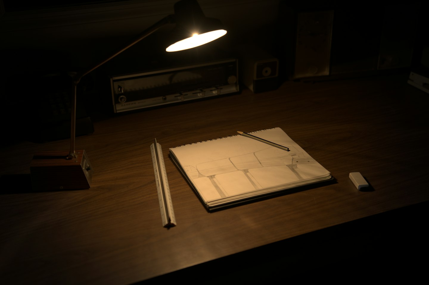 A sketchbook under a desk lamp